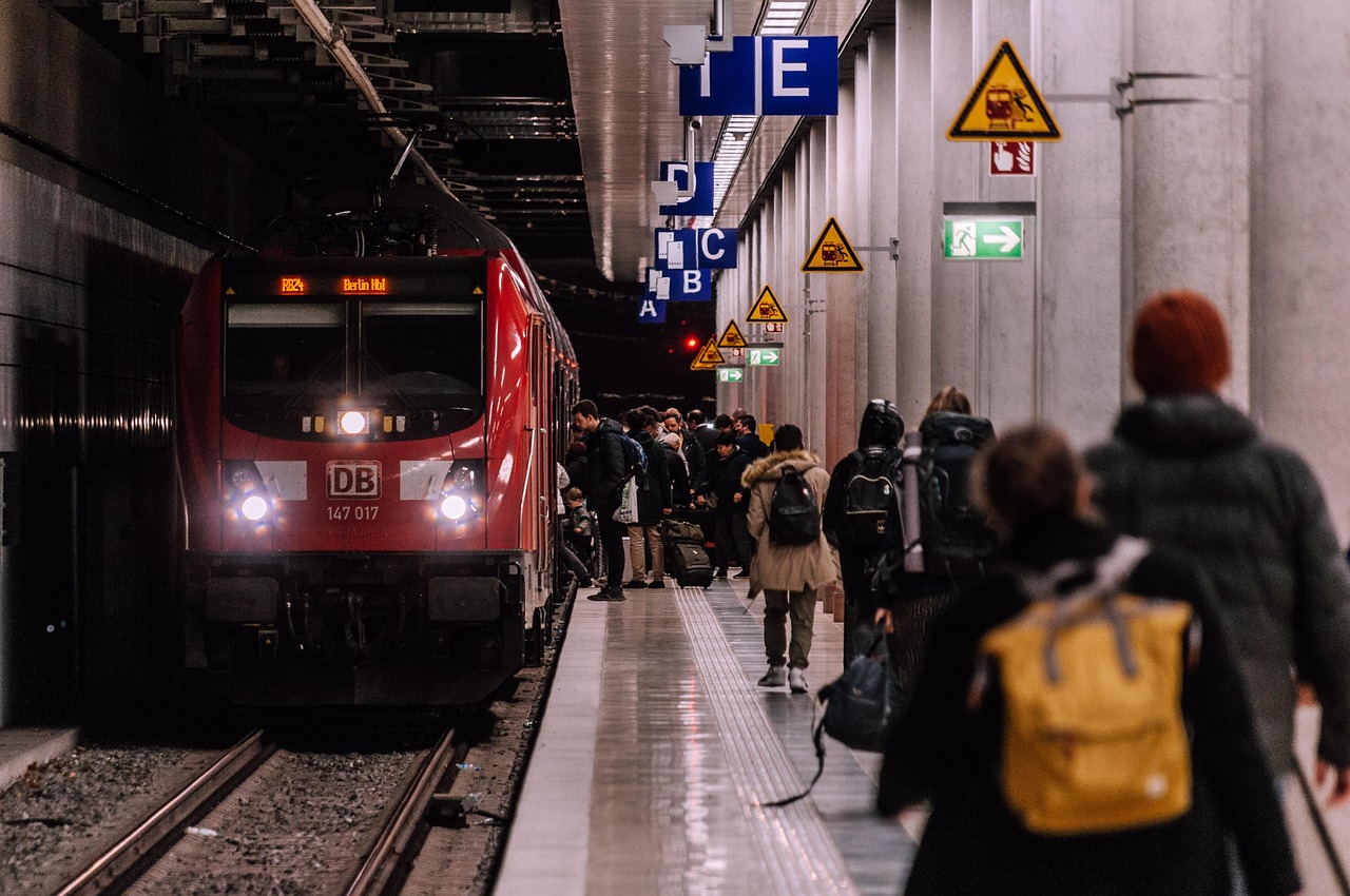 Regionalzug am Bahnsteig, Reisende steigen an den geöffneten Türen ein