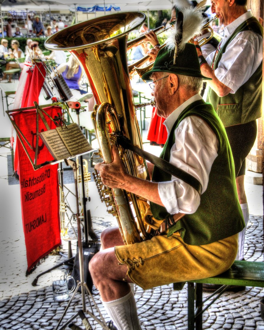Besucher an Biertischen im Biergarten des Englischen Gartens München an einem Sonntagvormittag