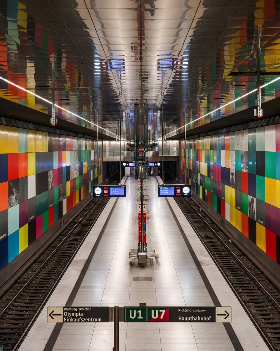 Leerer U-Bahnsteig mit Sitzbank und Wegweisern über der Bahnsteigkante