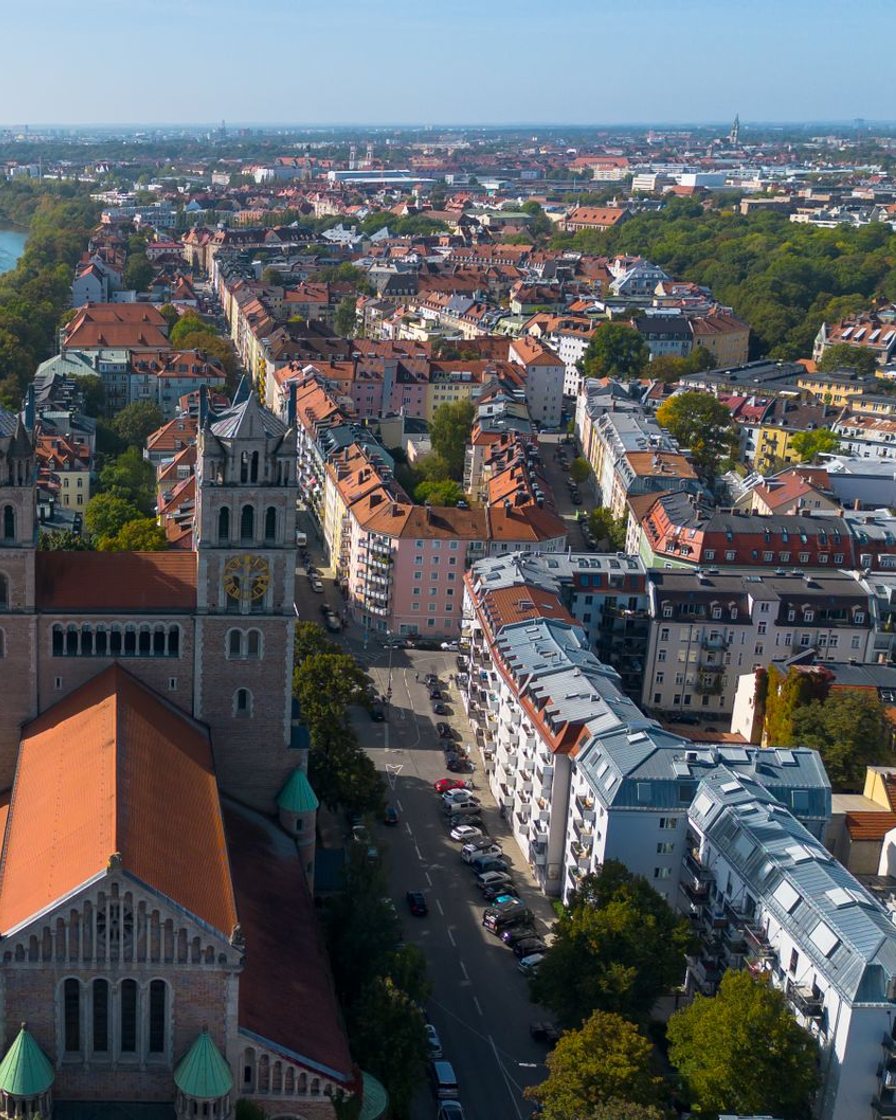 Die Isar im Stadtgebiet, dahinter Kirchtürme und die Dächer der Innenstadt
