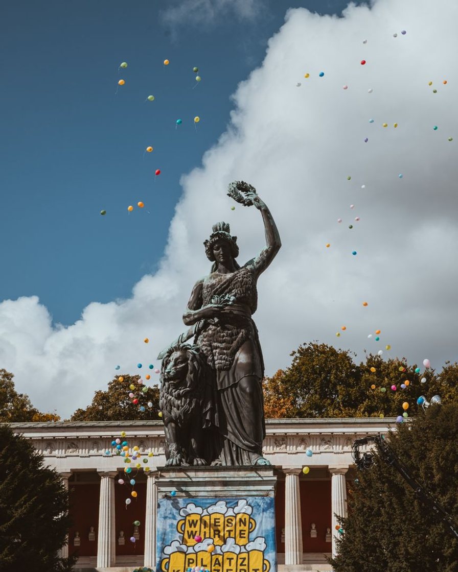 Die Bavaria-Statue mit der Ruhmeshalle über der Theresienwiese, davor die Dächer der Oktoberfest-Festzelte im Nachmittagslicht