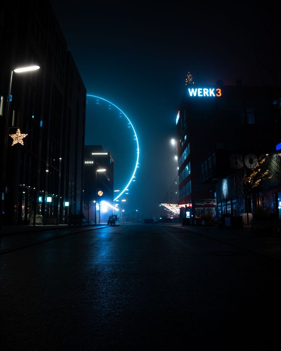 Beleuchtetes Riesenrad und Festzeltdächer auf der Theresienwiese am Abend, Blick von erhöhter Position